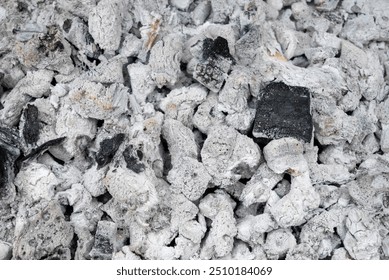 White embers of a barbeque fire with an odd couple of black coals. - Powered by Shutterstock