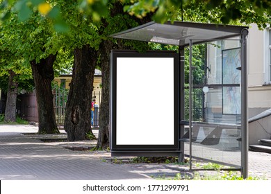 white empty advertising banner at a public transport stop of a trolley bus in the city near the park