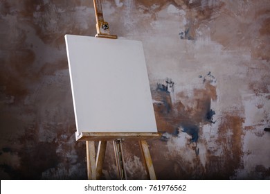 White Empty Artistic Canvas On An Easel For Drawing Images By An Artist On A Gray Background 