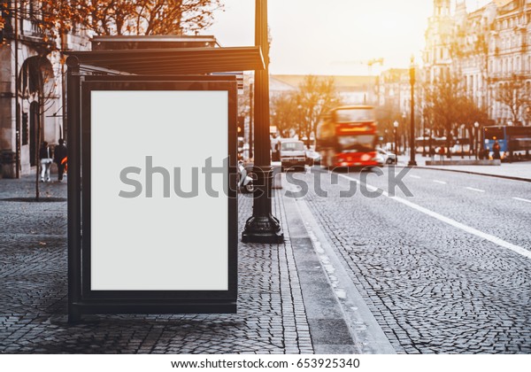 White empty information mock-up on city bus\
stop, blank vertical billboard near paved road with red touristic\
bus, clear placeholder frame in urban settings with copy space for\
text or advertising