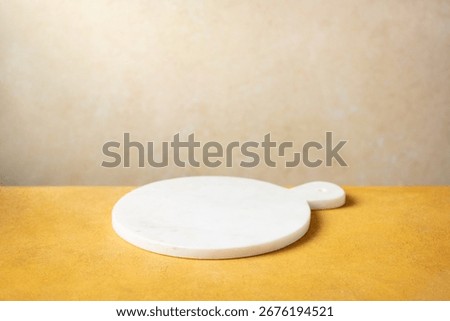 White empty marble serving board.  Beige background. Close up. Copy space.