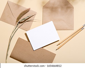 White Empty Paper Card With Stationery Set Of Envelopes, Notebook, Pencil. Blank Card Styled Mockup On Beige Background. To Do List, Greeting Card Or Writing A Letter Concept.