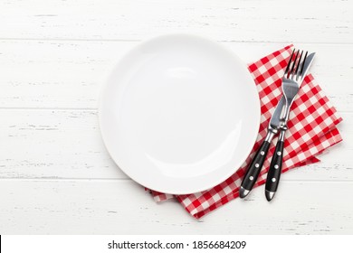 White empty plate, fork, knife and napkin on wooden table. Top view flat lay with space for your meal - Powered by Shutterstock