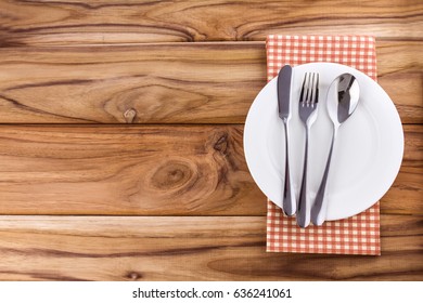  White Empty Plate With Fork And Spoon On Wooden Table 