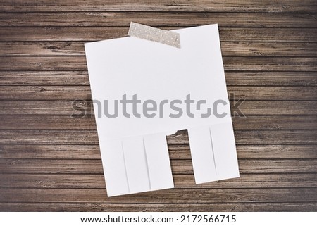 White empty tear-off stub paper note without text on wooden wall