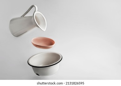 A White Enamel Jug For Water, Bowl And Soap Floating In The Air On A White Background