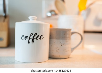 White Engraved Coffee Canister And Coffee Mug On Kitchen Counter