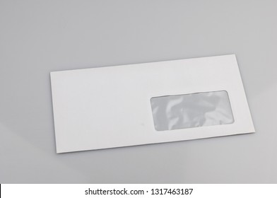 White Envelope With Address Window On Gray Background