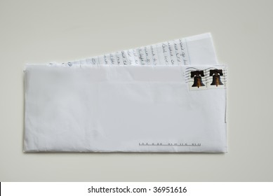 A White Envelope With A Hand Written Letter With Two Forever Stamps