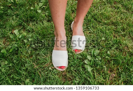 White espadrilles with open toe on female legs. Women's shoes