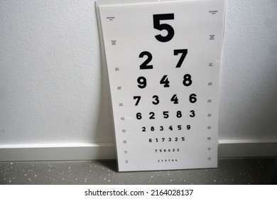 White Eye Chart For Eye Test In Front Of White Wall