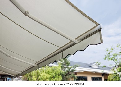 white fabric awning with the garden background. white canvas sun