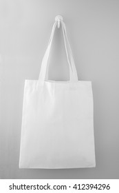 White fabric bag hanging on the gray wall