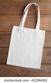 White Fabric Bag On Wooden Table