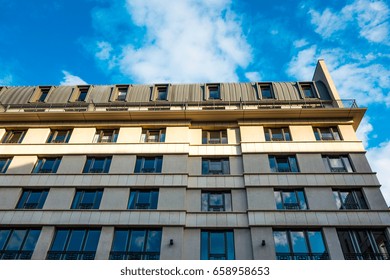 white facade of building with cloud reflections