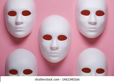 White face masks composition on pink background, fake identity or multiple personalities