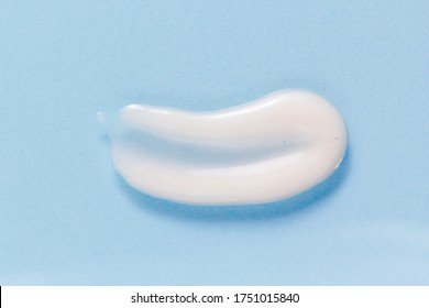 White Face Wash Gel Smear Smudge On Blue Background. Liquid Facial Cleanser Texture. Skincare Product Macro