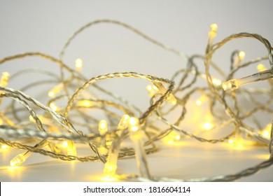 White Fairy Lights With Silver Wire Against A White Backdrop
