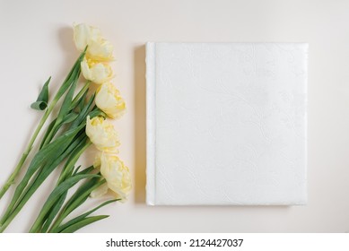 White Family Or Wedding Photo Book And Tulip Flowers Lie On A Light Beige Background. Fond Memories In Photographs For Memory