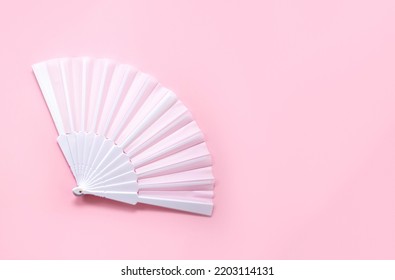 White Fan On Pink Background. Minimal Concept Of Menopause And Female Hot Flashes. Copy Space, Top View