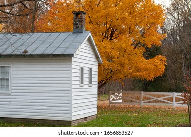 A White Farm Building With Fall Foilage Creates An Autumn Landscape