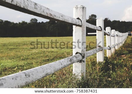 White farm fence boundary on mountain with grass field. Boundary separate concept.