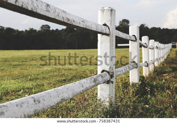 White farm fence boundary on mountain with grass\
field. Boundary separate\
concept.
