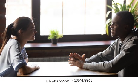 White female chatting with black male diverse people sitting at table chatting having first meeting during speed dating girl and guy liked each other, good first impression, romantic relations concept