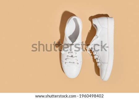 White female gumshoes on a beige background with copy space. View from above. Copy space. Foto stock © 