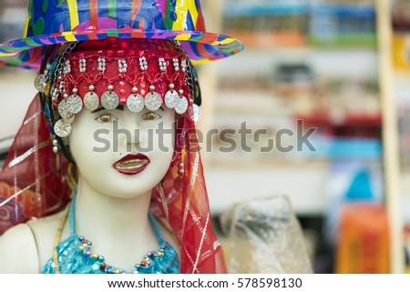 White female mannequin with painted lips in red oriental national headdress