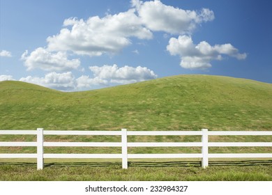 White Fence In Farm Field With Blue Sky