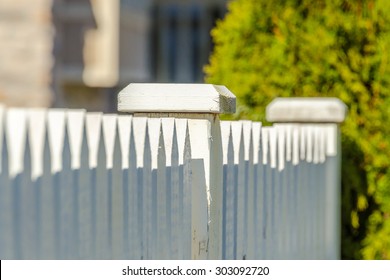 white fence with green lawn and houses.
