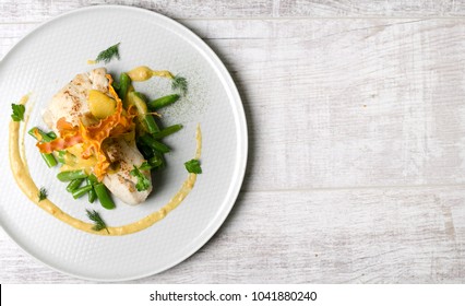 White Fish Baked With Beans On A White Plate