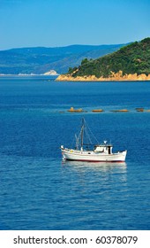 White fishing trawler anchored among islands of the Aegean Sea