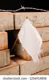 White flag on a wall, a multiple concept both on overworking and on immigration