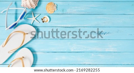 White flip-flops, starfish on blue wooden background. Vacation concept. Flat lay, top view, copy space