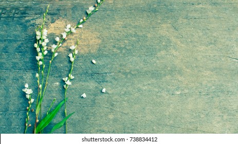 White flowers bouquet is placed on a wooden background.Vintage tone