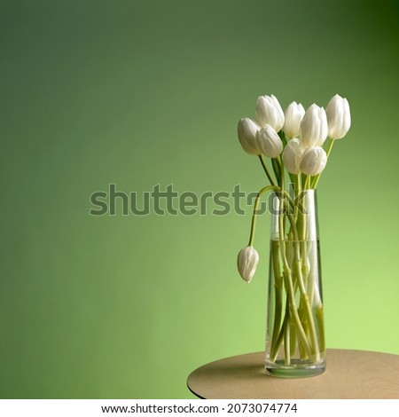 White flowers in vase with one drooping
