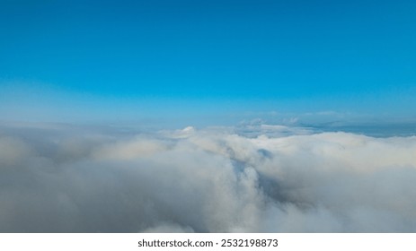 White fluffy clouds float above the mountaintops, forming a sea of ​​clouds. The blue sky in the morning, the sunlight shining on the fluffy clouds, it's like floating in heaven. wonderful nature
 - Powered by Shutterstock