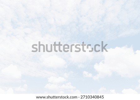 White fluffy clouds float in a blue sky. The scene captures a sense of openness and brightness, showing a typical midday sky with scattered clouds signaling fair weather.