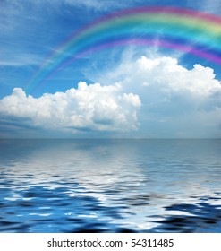 White Fluffy Clouds With Rainbow In The Blue Sky