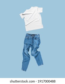 White Flying Cotton T-shirt, Blue Jeans Isolated On Blue Background. Clean White Unisex T-shirt. Branding Clothes. Mock Up For Your Design. Spring Summer Women's Clothing. Classic White Basic T-shirt