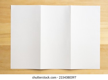 White folded paper on wood table background