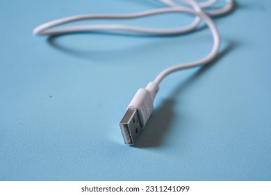White folded usb and micro usb cable on blue background. - Shutterstock ID 2311241099