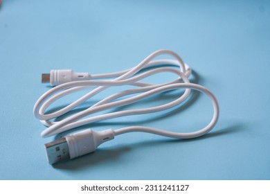 White folded usb and micro usb cable on blue background. - Shutterstock ID 2311241127