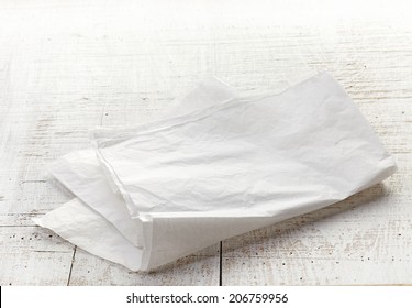 white folded wrapping paper on wooden table