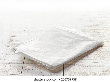 White Folded Wrapping Paper On Wooden Table
