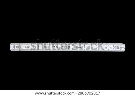 White Folding Ruler Fully Extended, Isolated on Black Background, High Contrast Studio Product Shot, Measurement Tool Concept