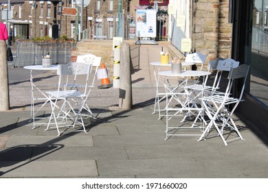  White Folding Table And Chairs On The Paving Outside A Cafe. Eating  Outdoors Concept. Lancashire, UK, 11-05-2021