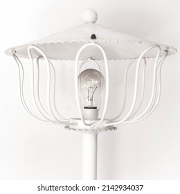 White forge vintage lamp with a modern light bulb. light turn off to save because of the high price of the electricity.